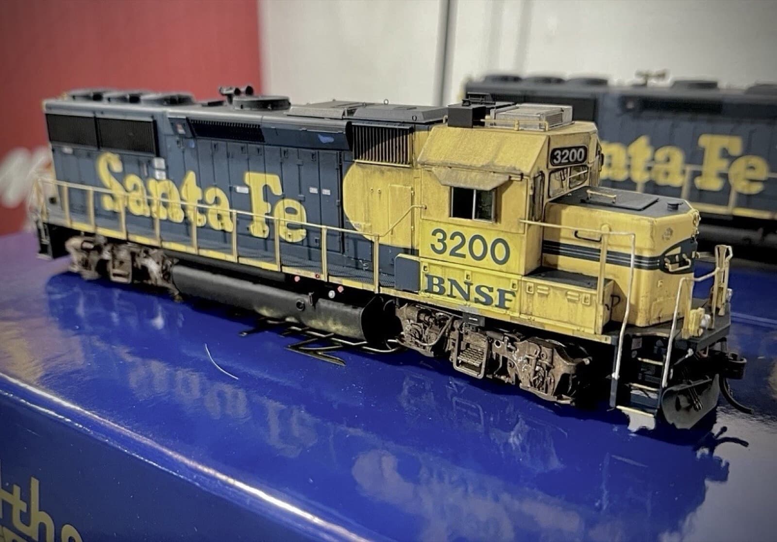青と黄色の「Santa Fe」の文字と「BNSF」のロゴの、ディーゼル機関車の模型。番号は3200。下に青い箱