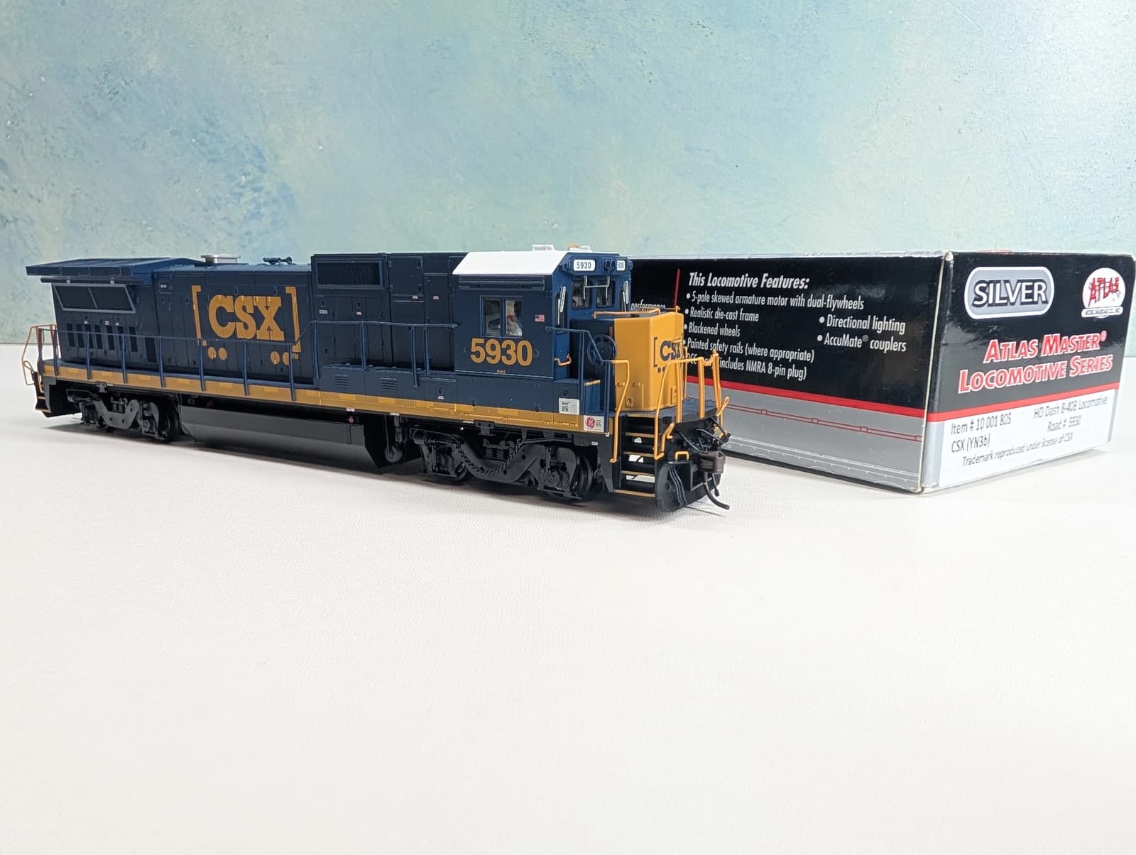 紺の車体に黄色い「CSX」の文字のディーゼル機関車の模型。右に黒い箱があり、「SILVER」の札と「ATLAS MASTER LOCOMOTIVE SERIES」の文字