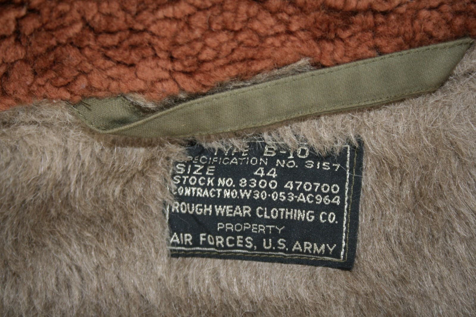 毛足のある裏地に縫い付けた黒いタグ。白い文字で「TYPE B-10」「CONTRACT NO. W30-053-AC964」「ROUGH WEAR CLOTHING CO.」と読める