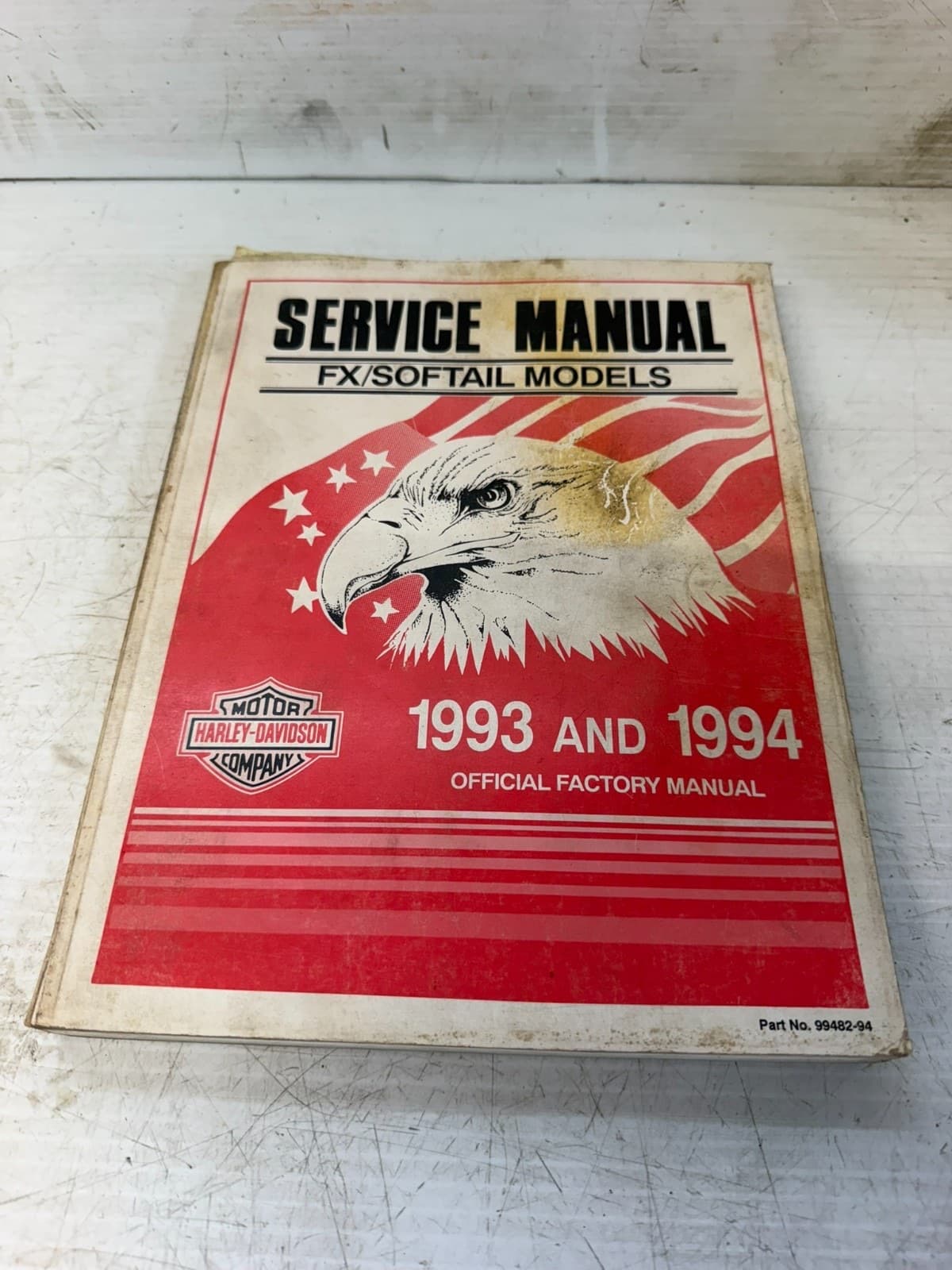 赤と白の表紙の冊子。「SERVICE MANUAL」「FX/SOFTAIL MODELS」「1993 AND 1994」の文字と、鷲の絵がある