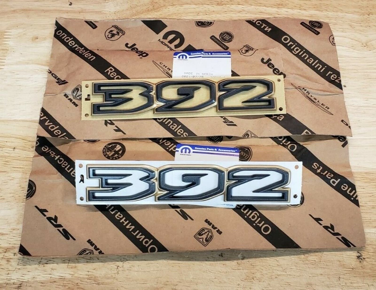 包み紙の上に置いた、「392」の文字のエンブレム2枚。文字は黒で、縁がブロンズ色