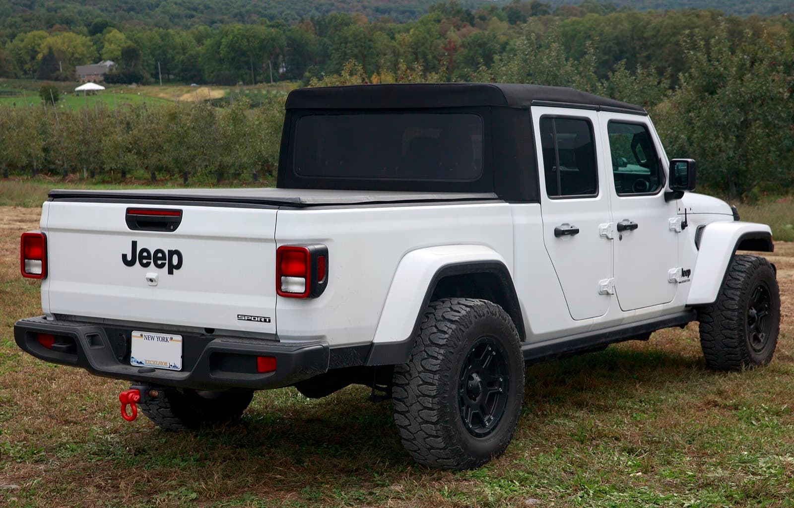 白いグラディエーターを右後ろから見た写真。荷台にカバー、テールゲートに Jeep の文字