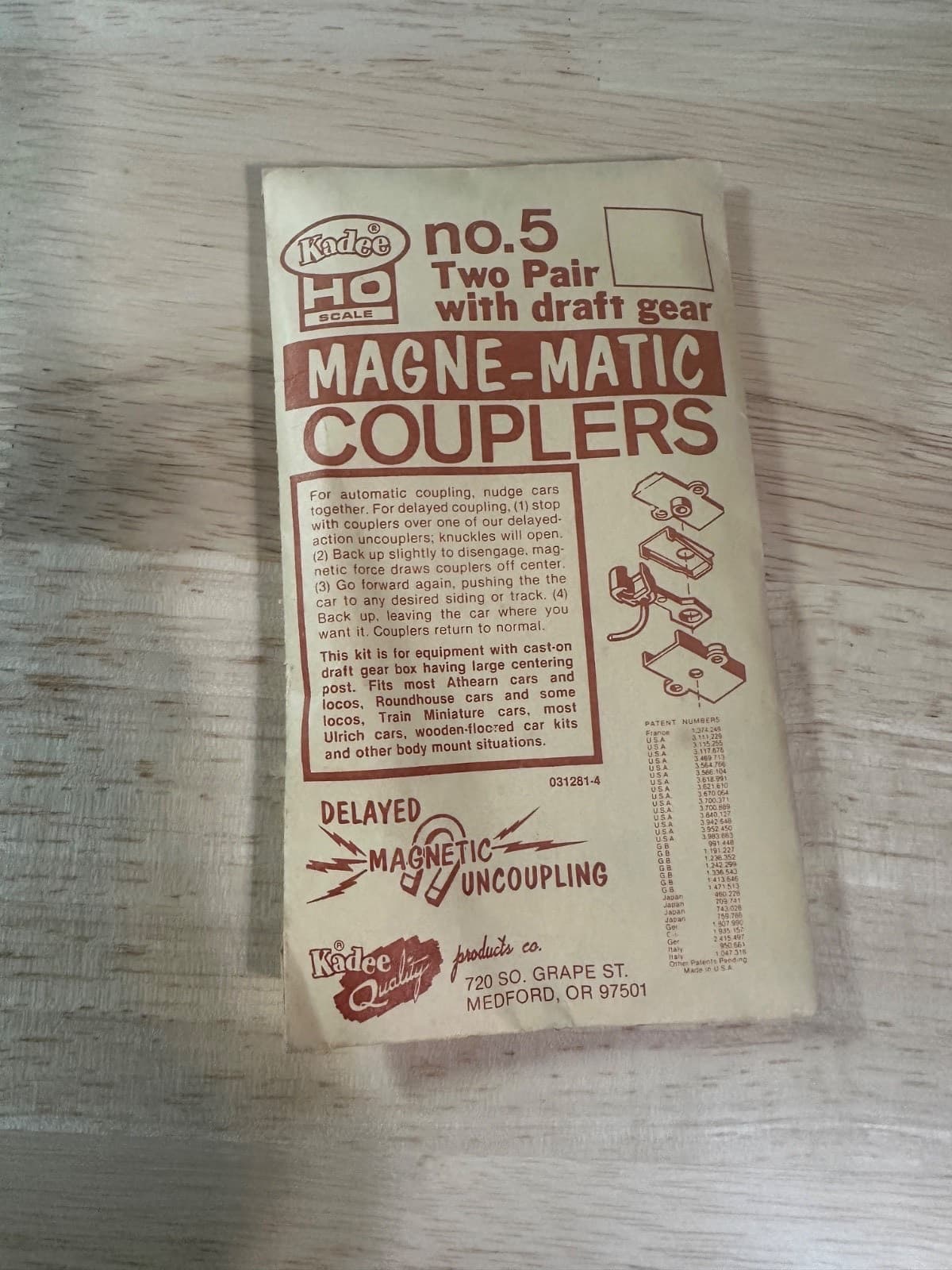 セカイモンの出品の写真。木の板の上に置いた、茶色の文字の袋。「no.5 Two Pair with draft gear」「MAGNE-MATIC COUPLERS」とある