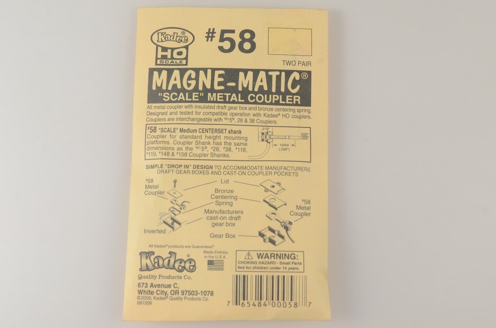 セカイモンの出品の写真。灰色の地に置いた、黄色い台紙の Kadee の#58。「SCALE METAL COUPLER」の文字がある