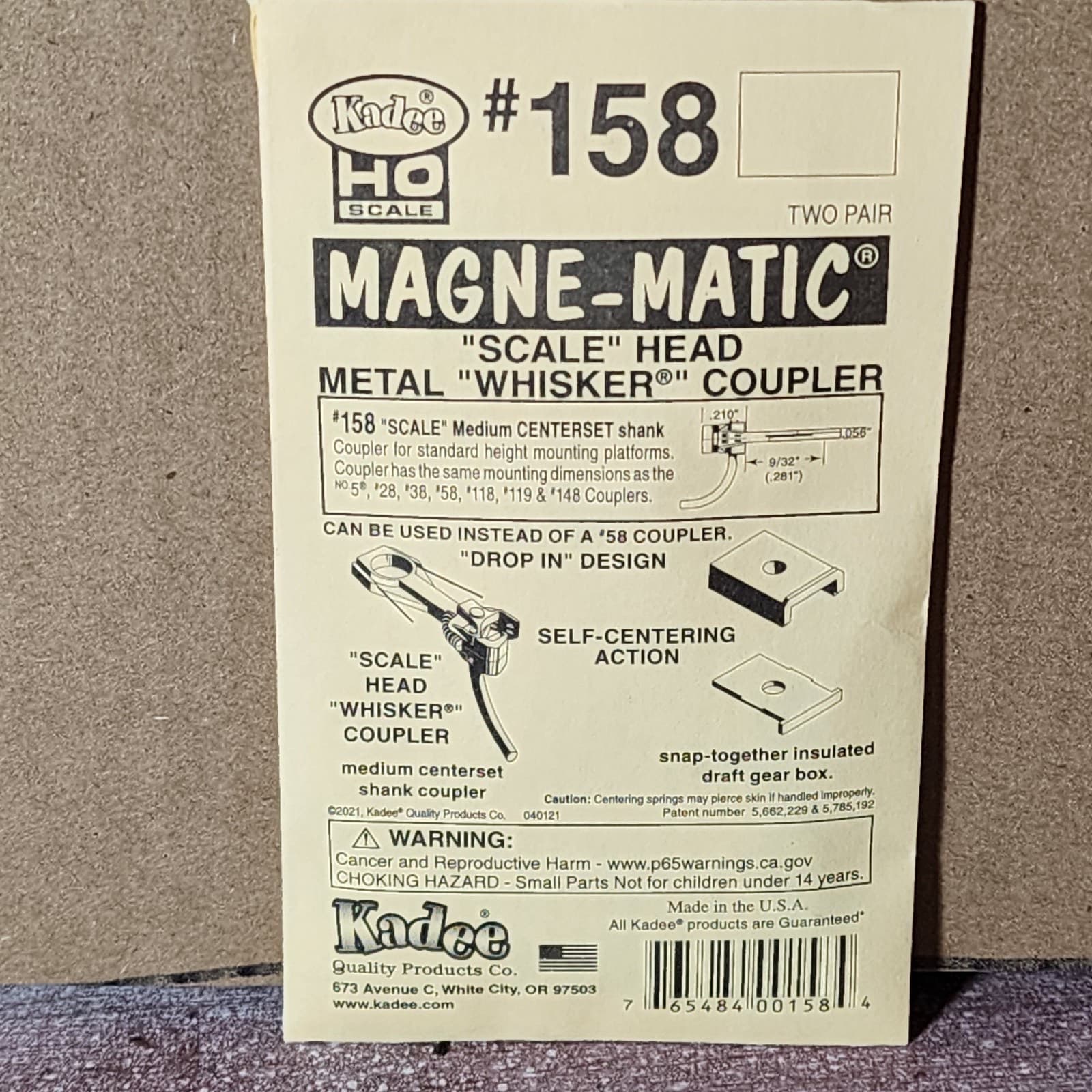 セカイモンの出品の写真。黄色い台紙の Kadee の#158。「SCALE HEAD」「WHISKER COUPLER」の文字と、取り付けの図がある