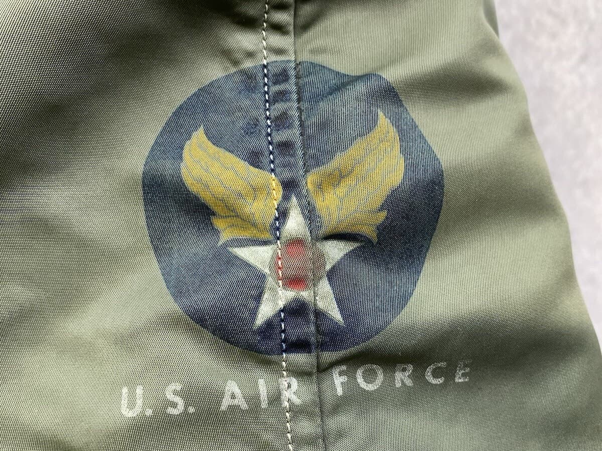 光沢のある緑の生地に印刷された、紺の丸に黄色の翼と白い星のマークと「U.S. AIR FORCE」の白い文字
