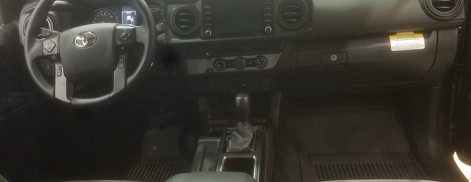 タコマの運転席まわりを正面から見た写真。ハンドルの右に、両脇にボタンの並ぶ四角い画面がある