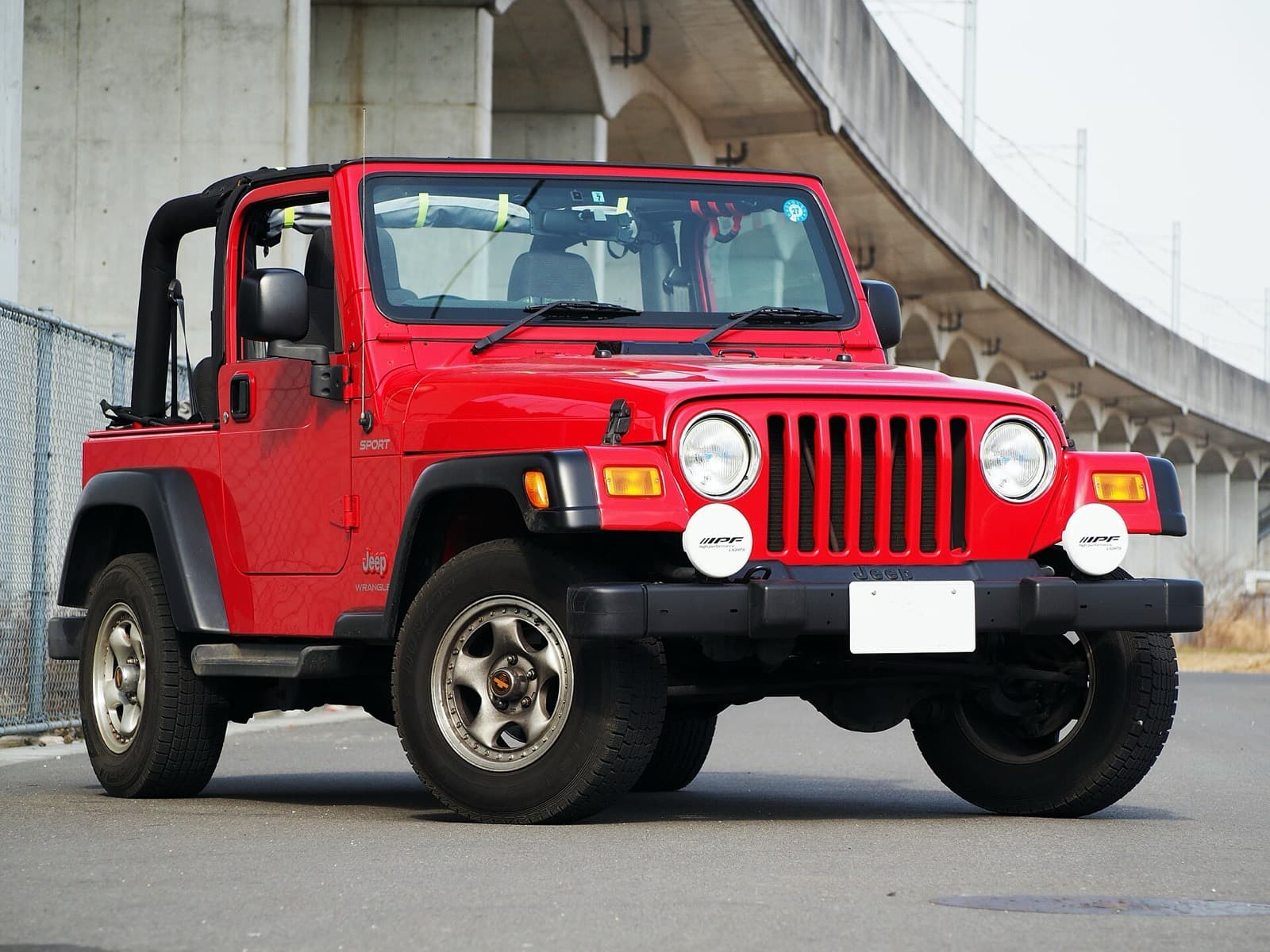 幌を外した赤い2ドアのラングラーTJ。前に丸いフォグランプ