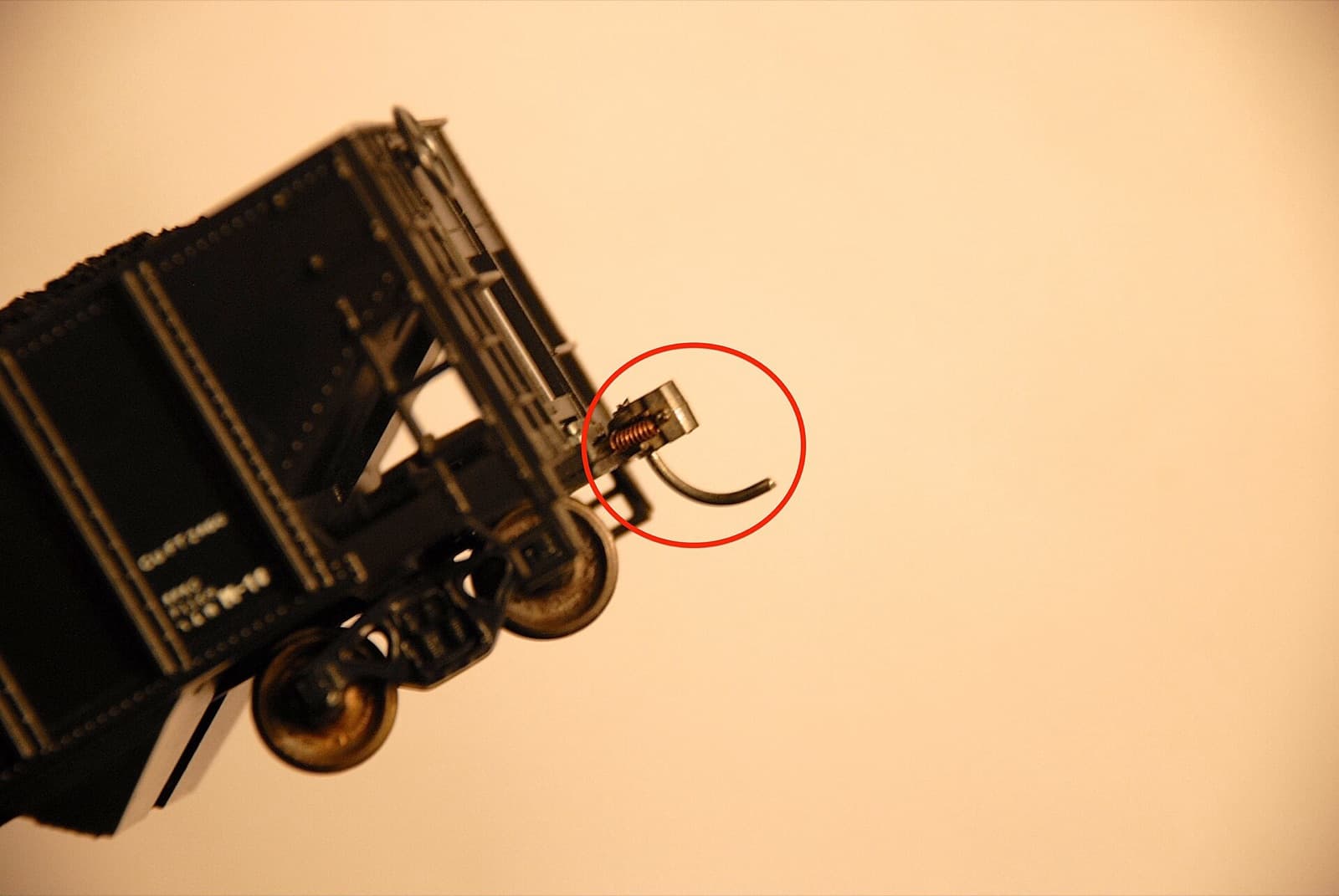 貨車の模型の端を下から写した写真。赤い丸の中に連結器と下に垂れた針金